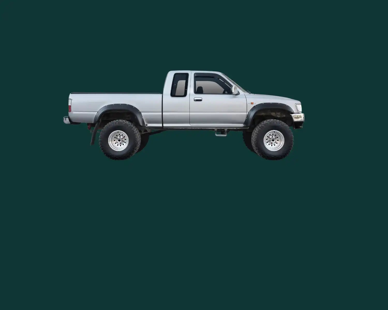 Silberner Toyota Pickup-Truck mit höhergelegtem Fahrwerk und verlängertem Fahrerhaus.