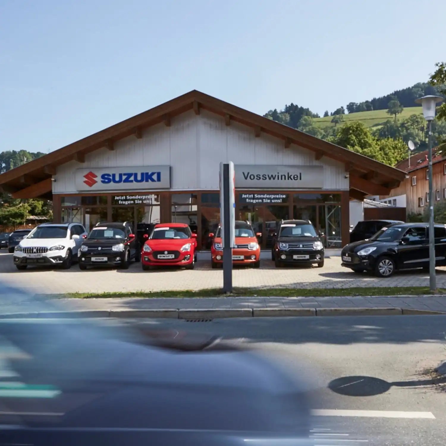 Suzuki-Autohaus mit Fahrzeugen davor geparkt.