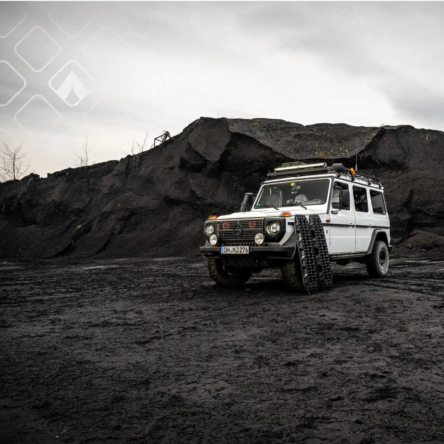 Weißer Mercedes-Benz G-Klasse mit Offroad-Modifikationen und Dachträger.