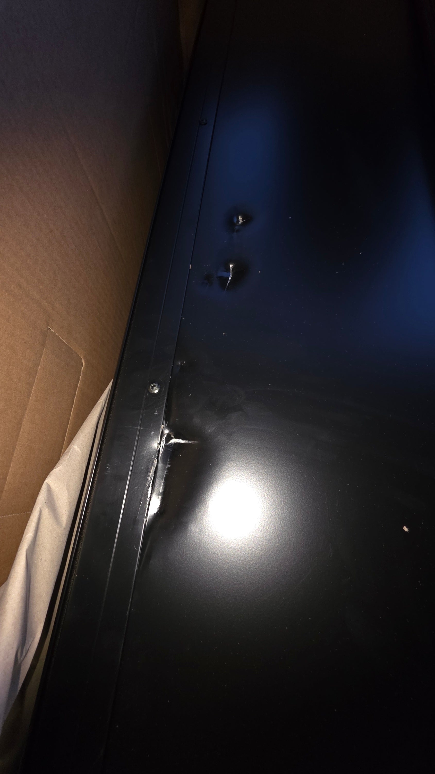 Schwarze glänzende metalltür mit sichtbaren schrauben und reflektierender oberfläche des dachzelts cumaru light